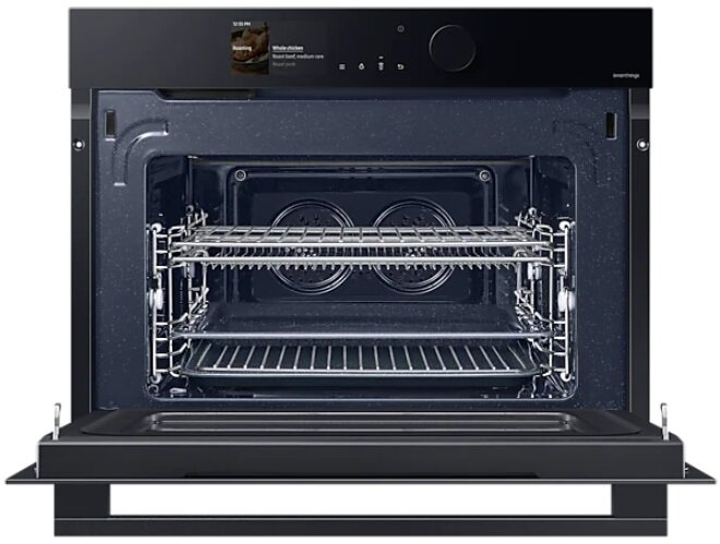 Czarny piekarnik z otwartymi drzwiami. Wnętrze z rusztami, wyświetlacz pokazuje pieczeń i kurczaka.