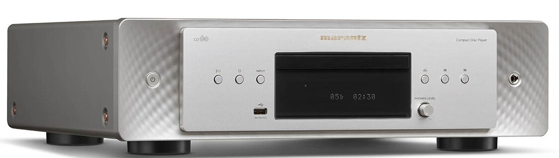 Srebrny odtwarzacz CD Marantz. Posiada wyświetlacz, przyciski i gniazdo na płyty CD.
