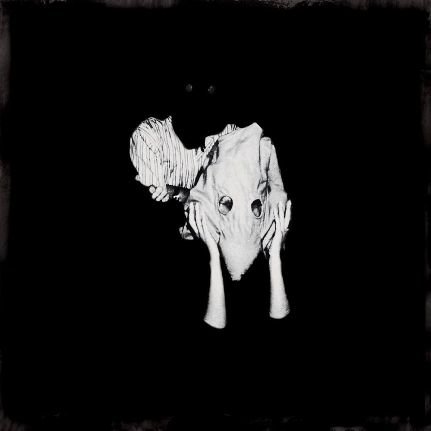 Monochrome Bild einer Person mit Maske und zwei Augenlöchern.