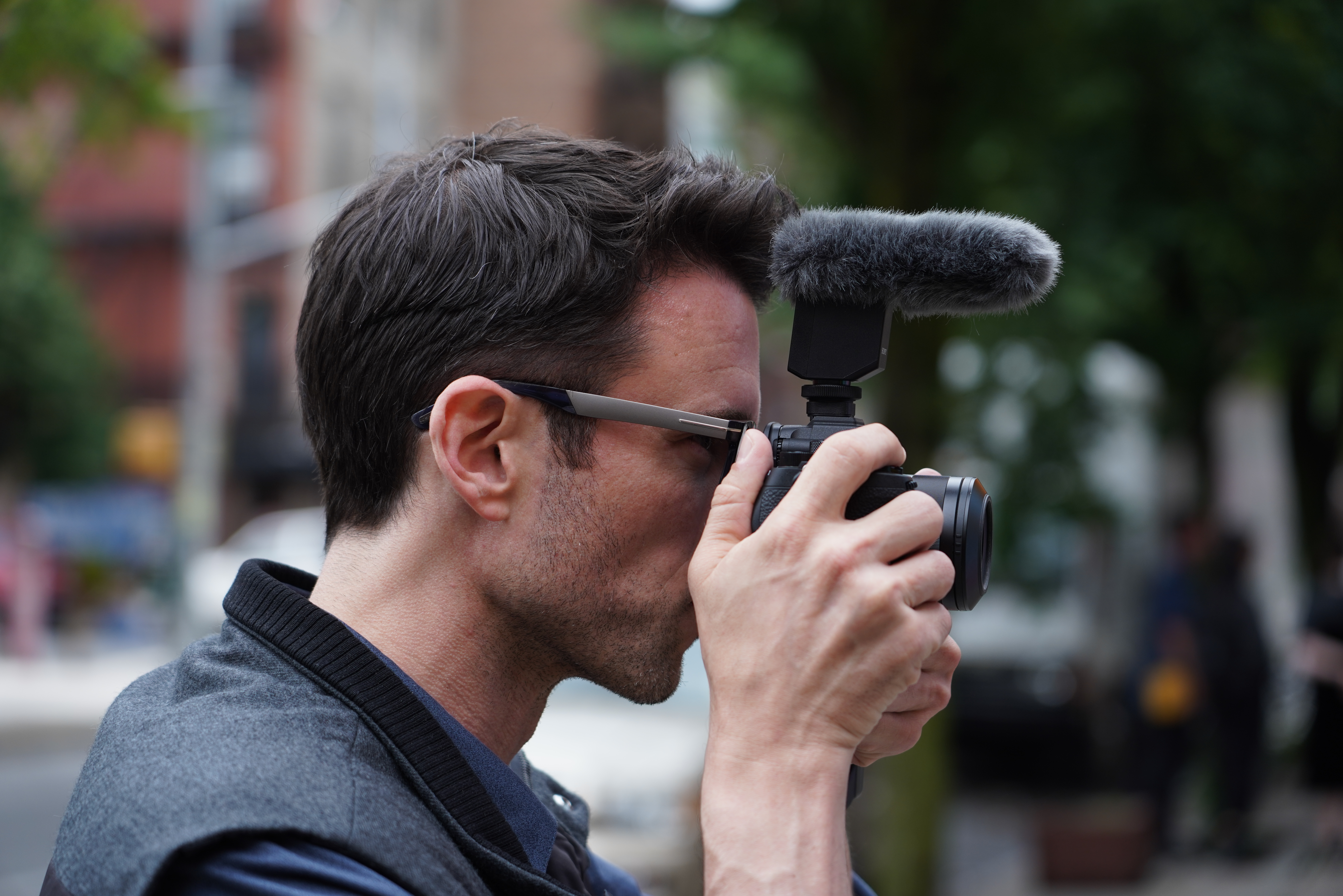 Un homme tenant un appareil photo avec un microphone.