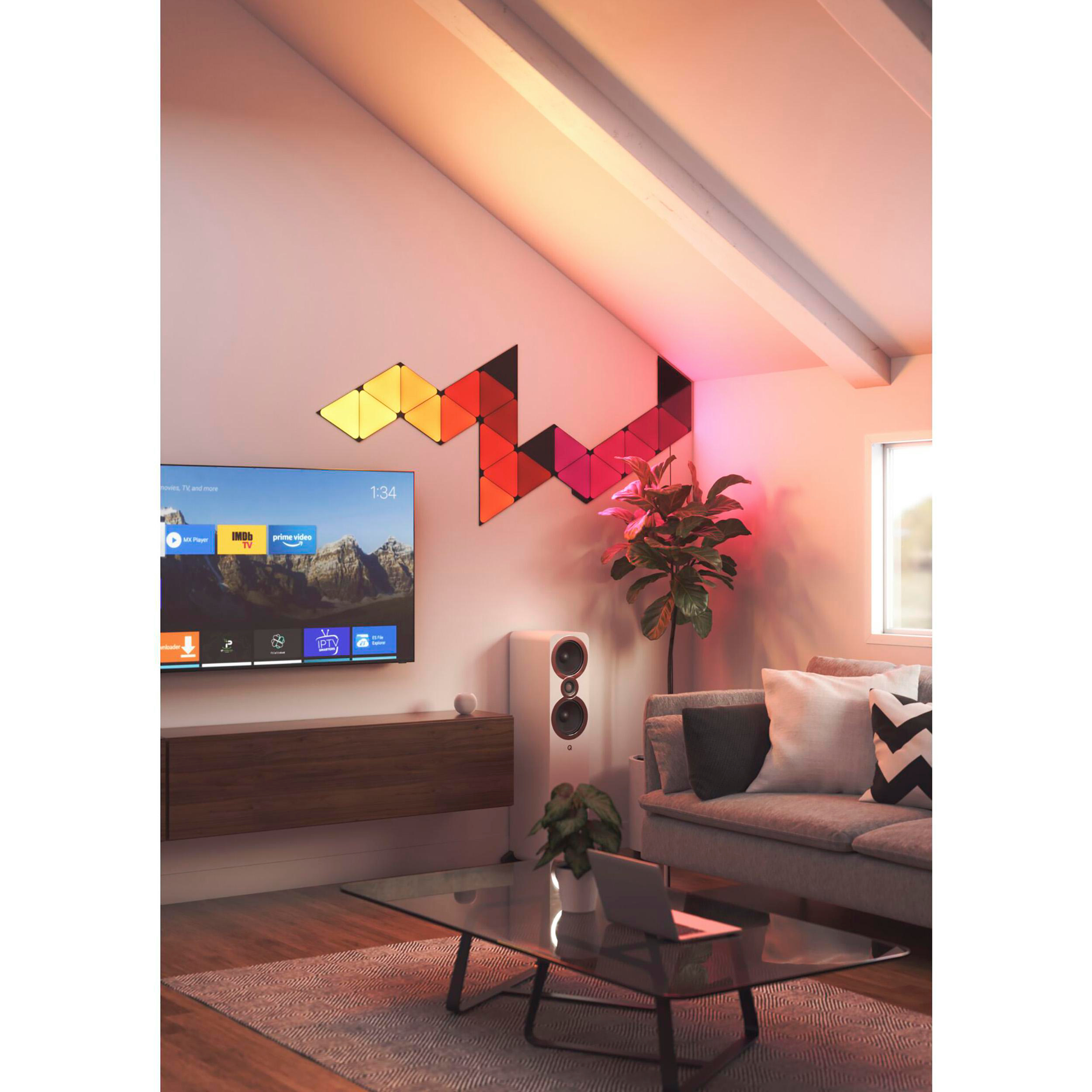 Wohnzimmer mit Fernseher, Lautsprechern und dekorativen Wandleuchten.