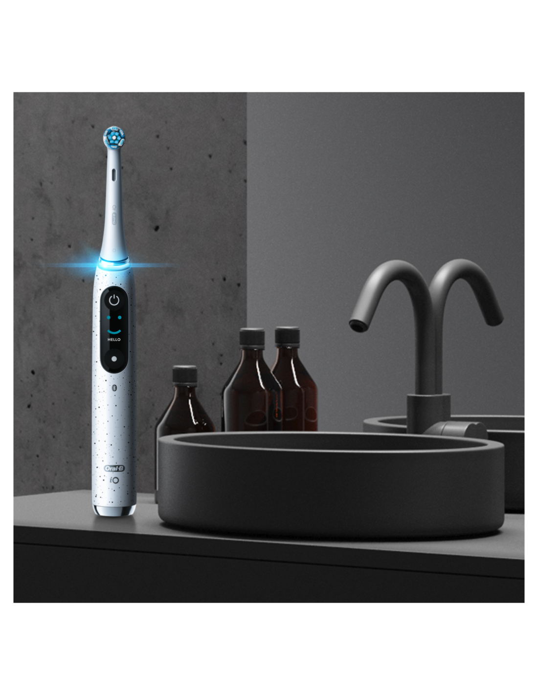 Elektrikli bir diş fırçası ve banyo aksesuarları, nötr bir arka plan üzerinde bir tezgahta.