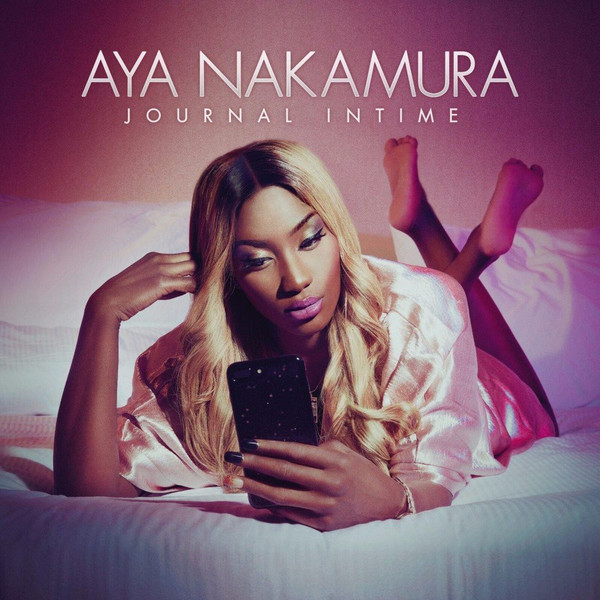 Pochette de l'album 'Journal Intime' d'Aya Nakamura. Elle est sur un lit, tenant un téléphone, fond rose.