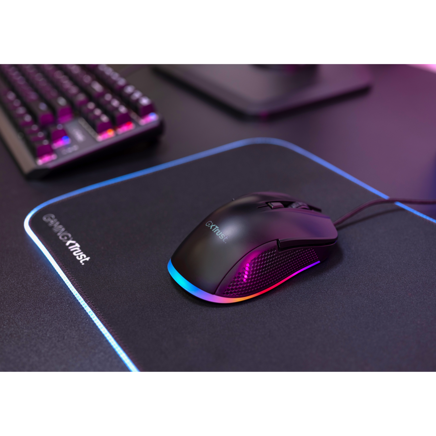 Black gaming mouse with RGB lighting on a black mousepad.