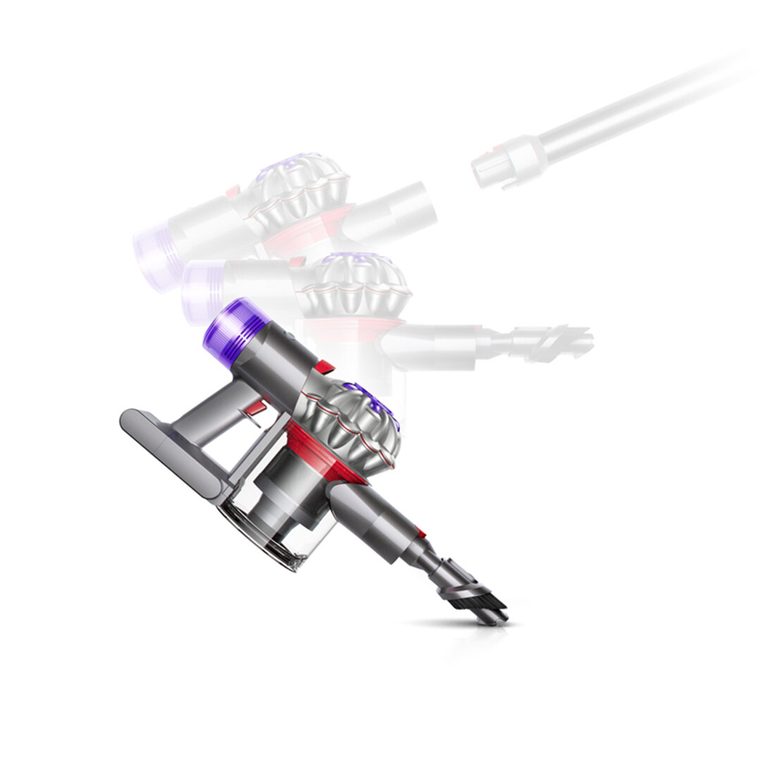 Odkurzacz Dyson w akcji. Srebrny korpus z fioletowymi i czerwonymi akcentami. Białe tło.