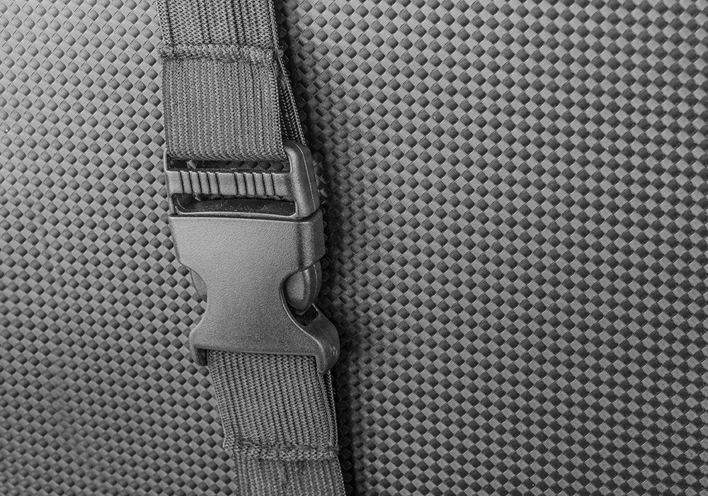 Czarny zatrzask na pasku na teksturowanej tkaninie.