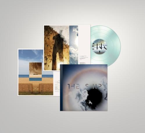 Album borító, fotók és egy világoskék bakelit lemez világos háttéren.