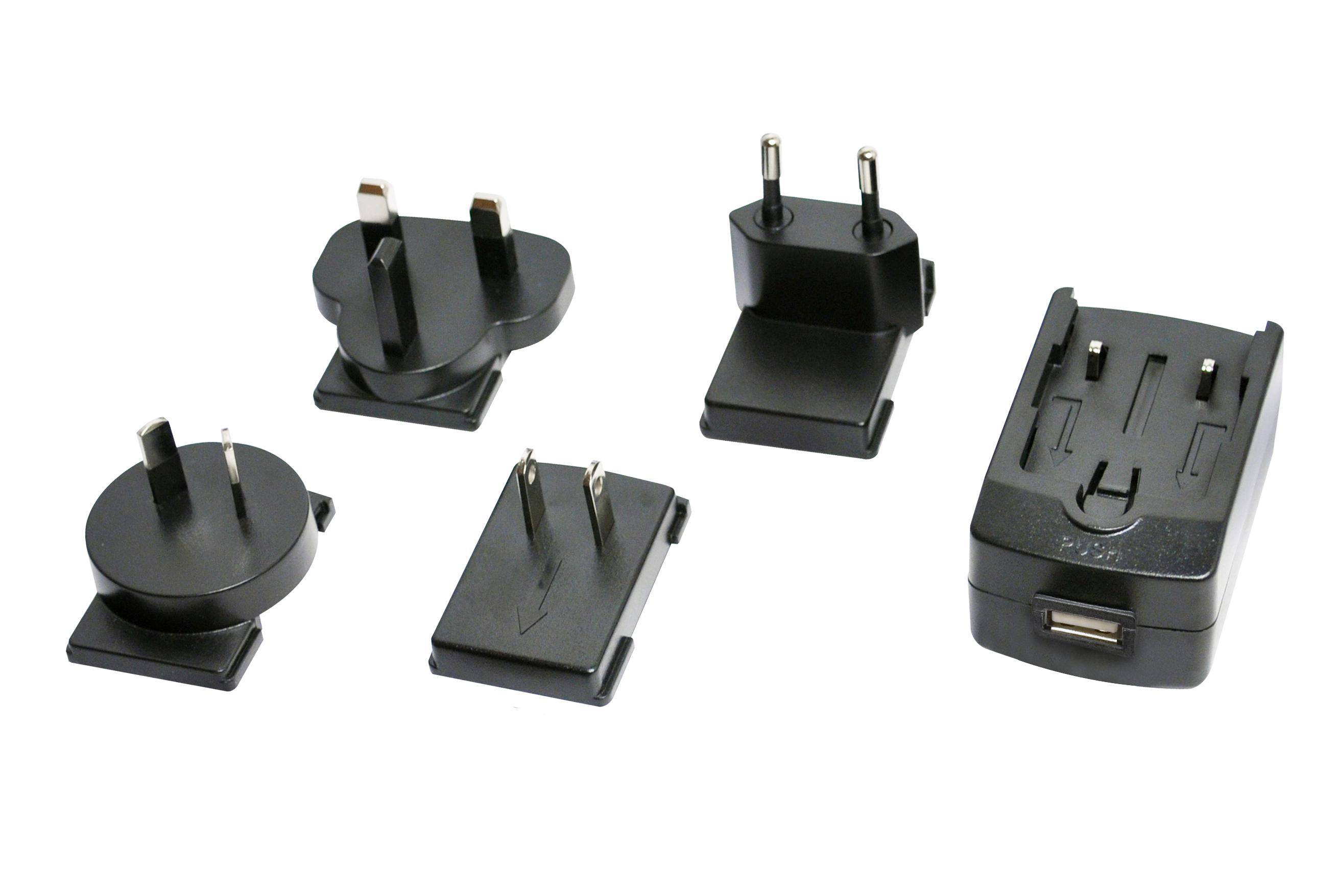 Fünf schwarze Netzadapter mit verschiedenen Steckertypen sind auf einer weißen Oberfläche angeordnet.