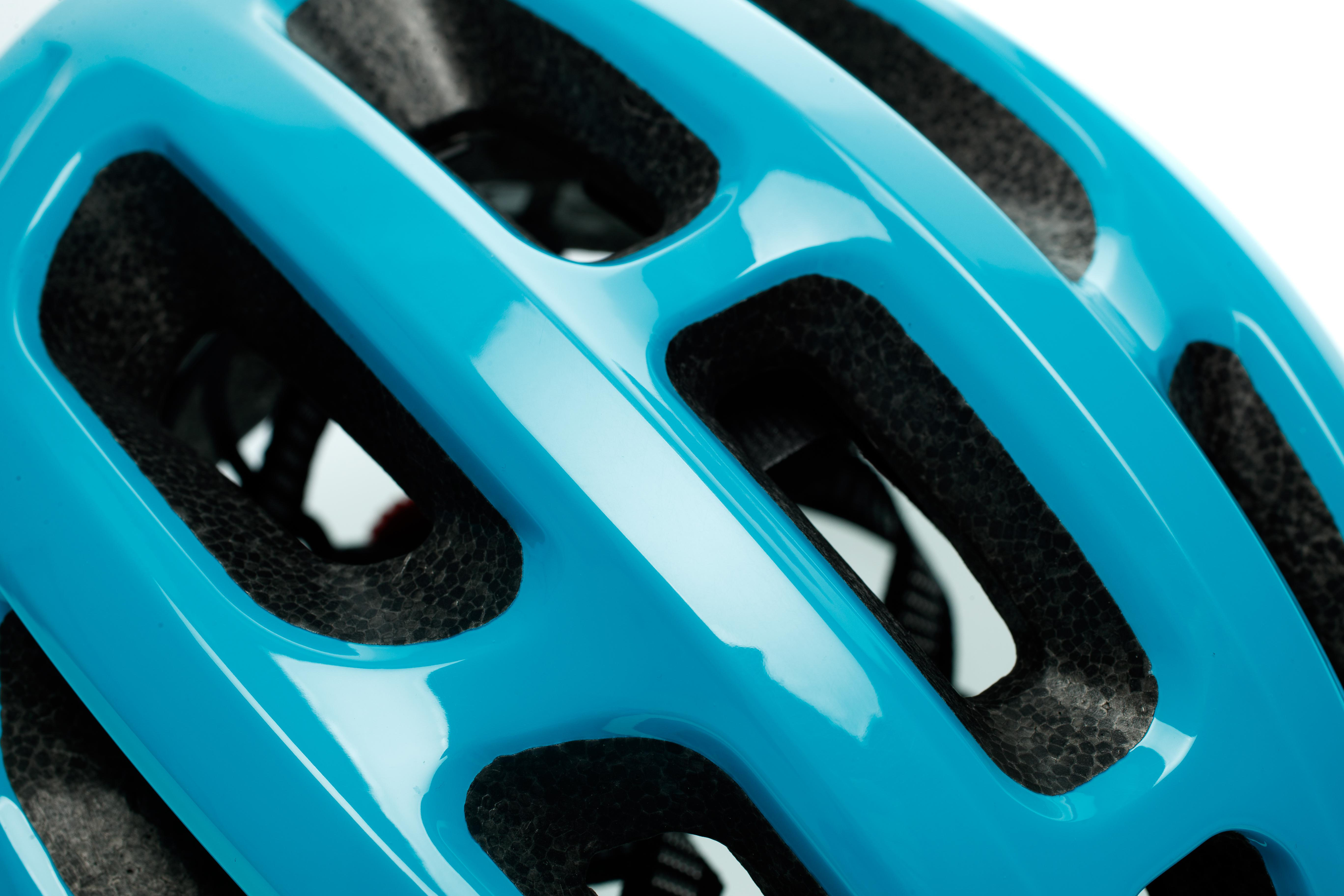 Nahaufnahme eines blauen Fahrradhelms mit Belüftungslöchern und schwarzer Polsterung.
