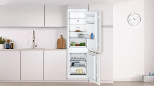 Un refrigerador con la puerta abierta. Dentro, hay estantes con alimentos.