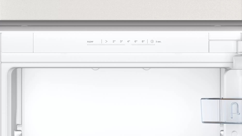 Interior blanco del refrigerador. Panel de control arriba, ajustes de temperatura visibles. Vacío por dentro.
