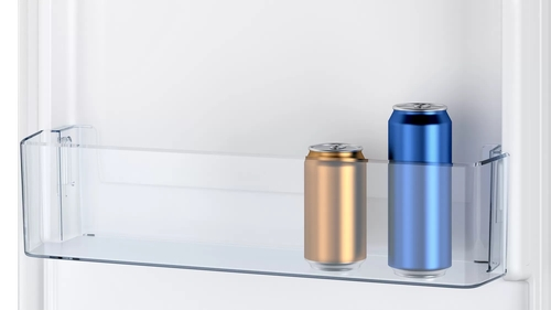 Dentro de un estante de refrigerador con dos latas: dorada y azul, fondo blanco.