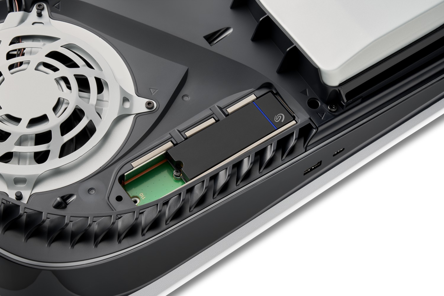 Inneres einer PS5-Konsole mit Lüfter, schwarzer SSD und sichtbaren internen Komponenten.