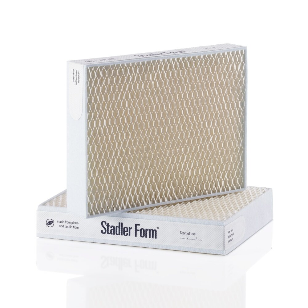 Dwa białe filtry powietrza Stadler Form ułożone na białej powierzchni.