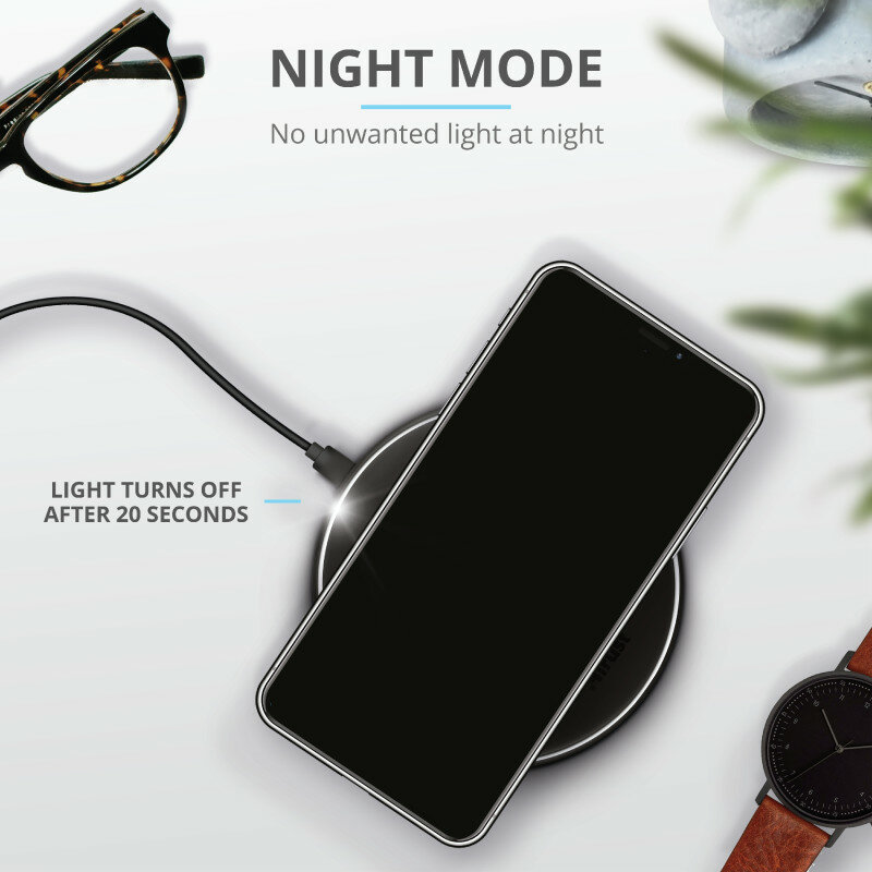 Telefon ładuje się na ładowarce bezprzewodowej. Obok okulary i zegarek. Tekst: Tryb nocny.