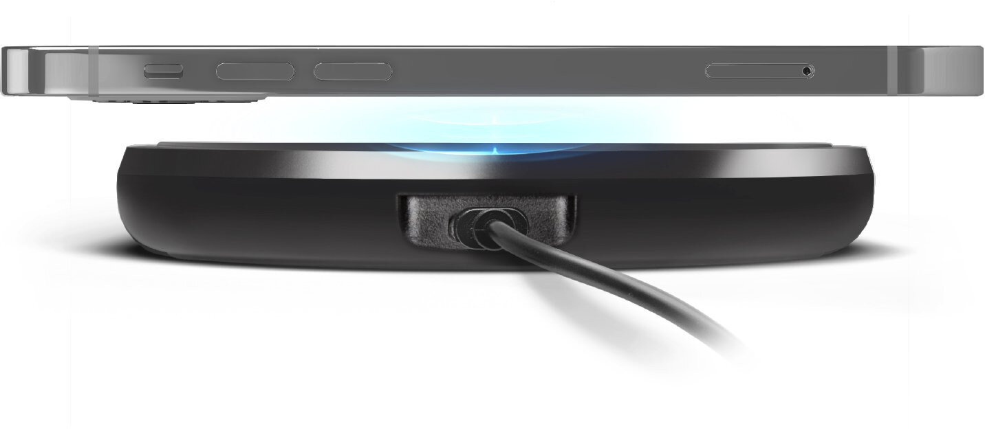 Telefon umieszczony na czarnej ładowarce bezprzewodowej, z kablem.