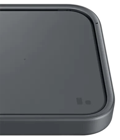 Zbliżenie czarnej ładowarki bezprzewodowej. Ma kwadratowy kształt z obramowaniem.