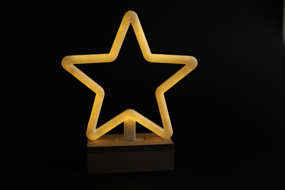 Neon w kształcie gwiazdy na czarnym tle.