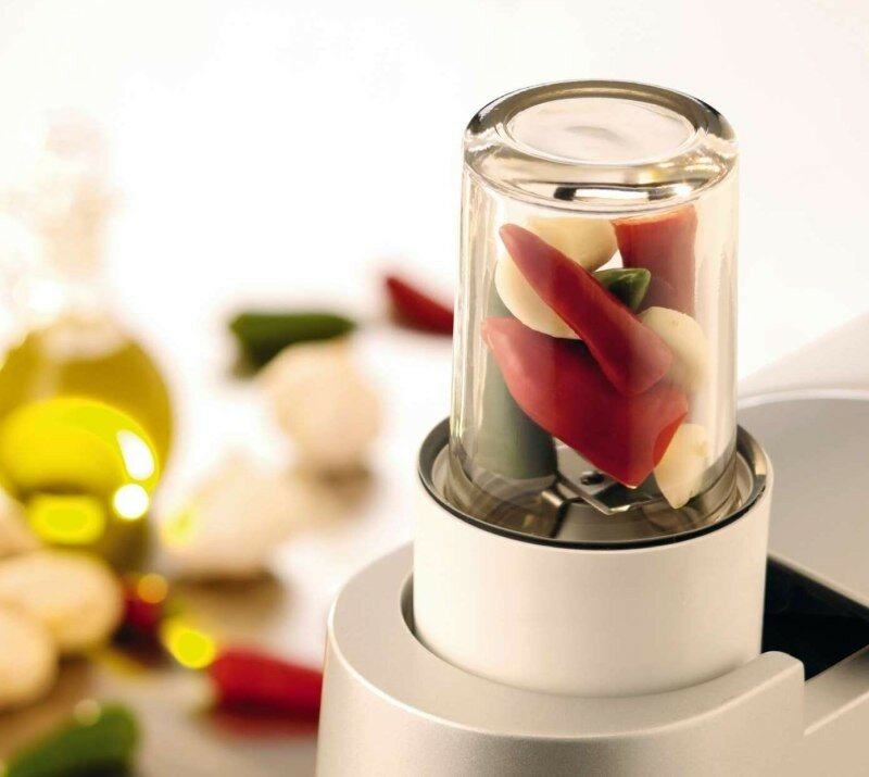 Blender z czerwoną papryką i czosnkiem w szklanym pojemniku.