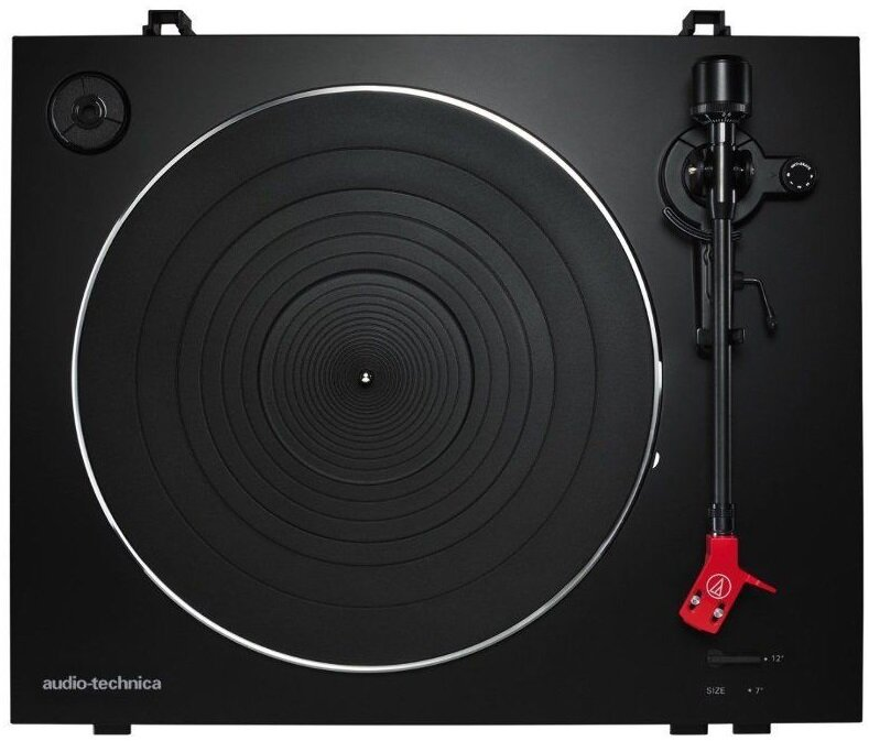 Czarny gramofon z czarnym talerzem i czerwoną wkładką na czarnej powierzchni, ujęcie z góry.