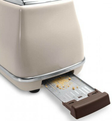 Beżowy toster w stylu retro z wysuniętą tacką na okruchy, zawierającą okruchy.