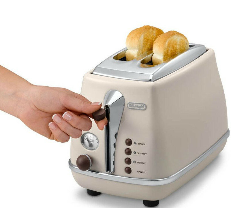 Beżowy toster DeLonghi z dwiema kromkami chleba, ręka regulująca pokrętło.