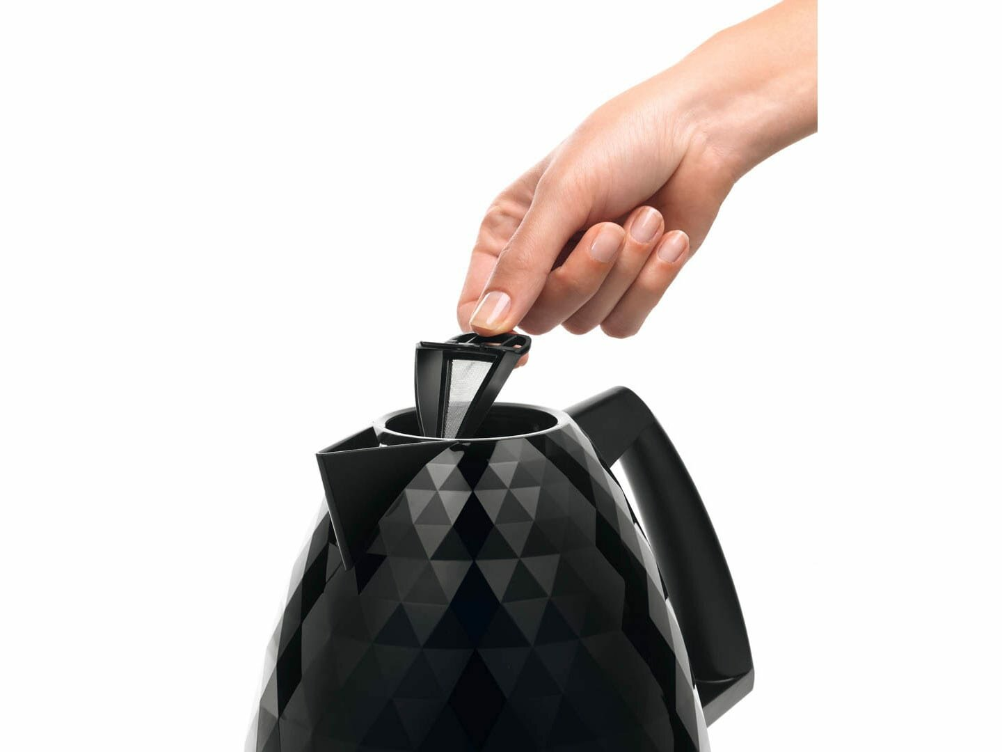 Ręka wkładająca filtr do czajnika elektrycznego z czarnym wzorem.