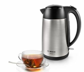 Srebrny i czarny czajnik elektryczny z filiżanką herbaty, a filiżanka stoi na talerzu.