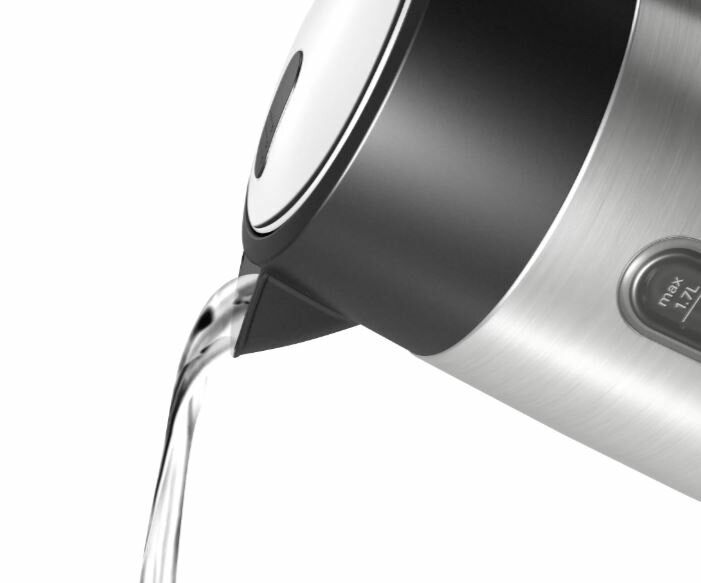 Czajnik nalewający wodę. Czajnik jest srebrny i czarny. Woda wypływa z wylewki.