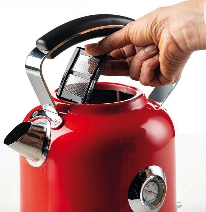 Czerwony czajnik, dłoń wkładająca filtr, białe tło.