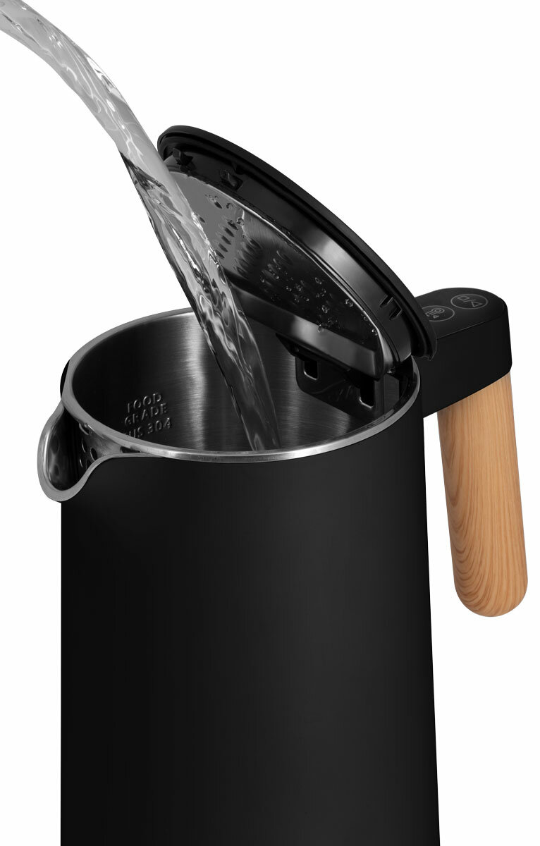 Woda wlewana do czarno-srebrnego czajnika z drewnianym uchwytem.