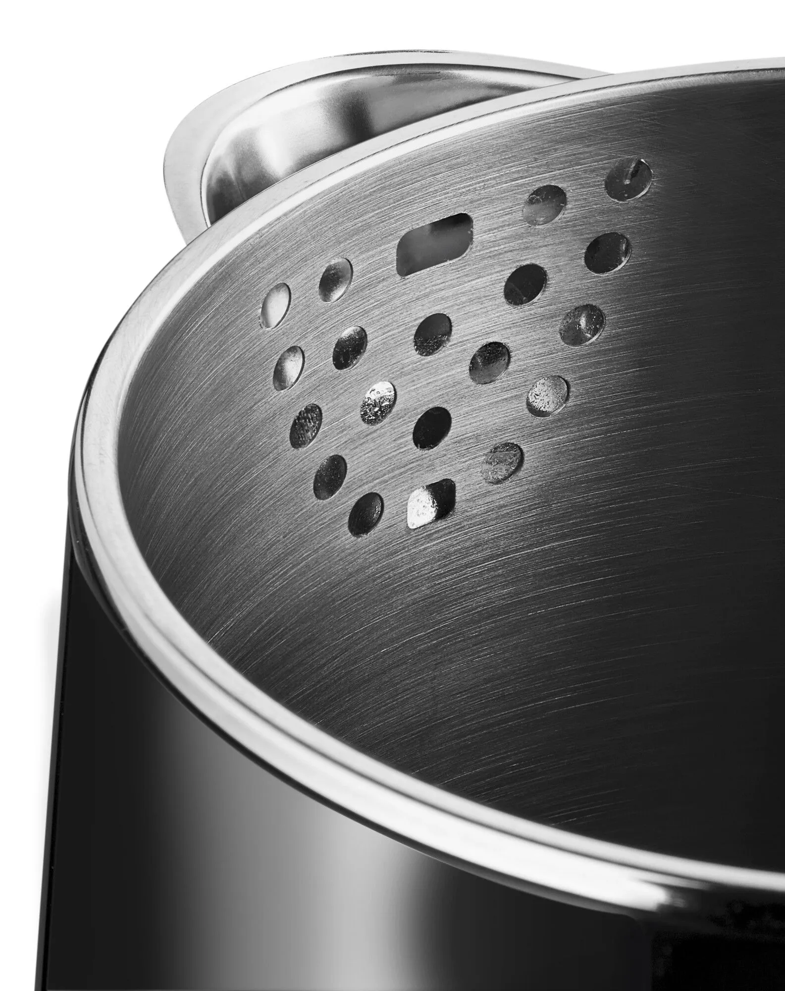 Zbliżenie metalowego garnka. Ma otwory wokół górnej części. Srebrny kolor.