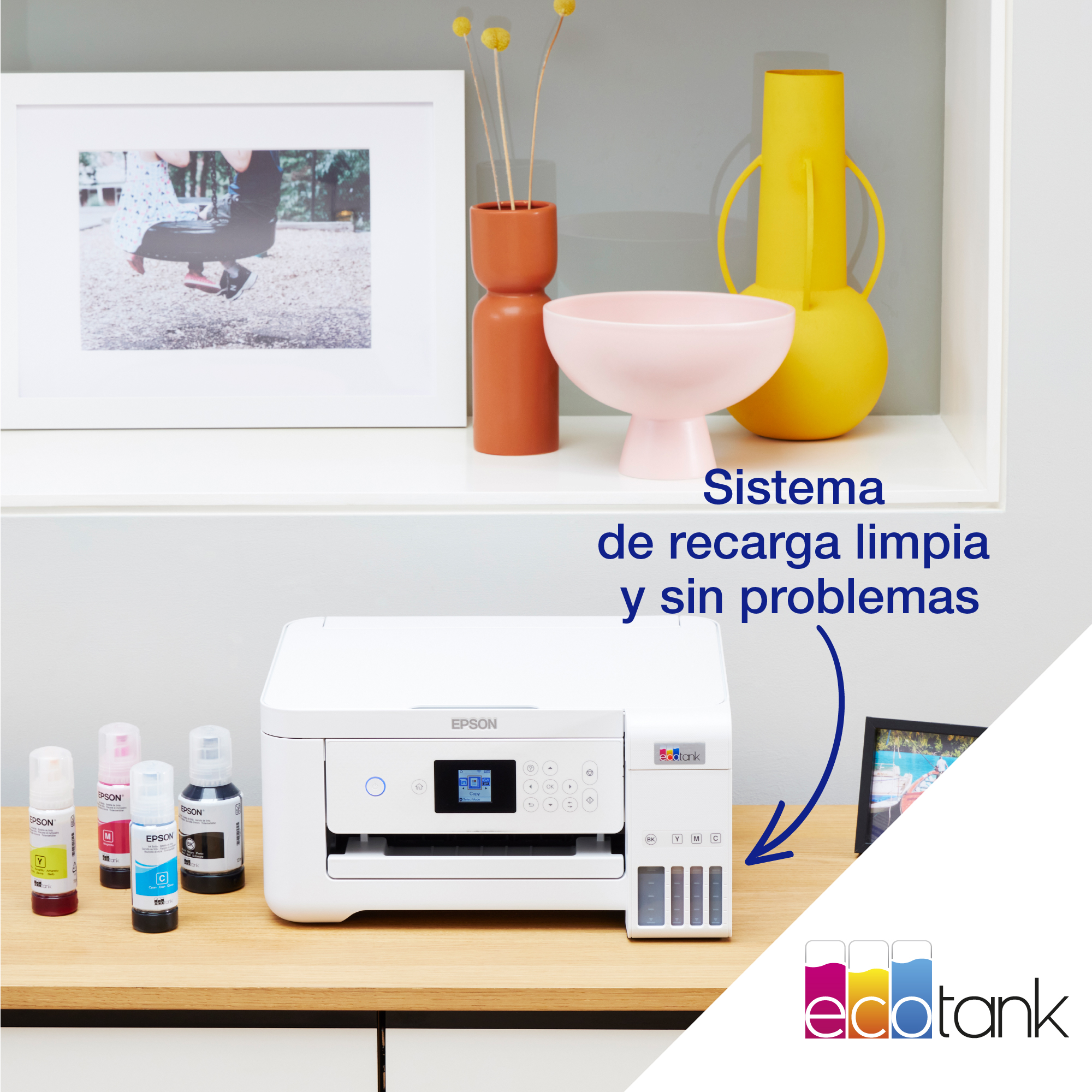 Impresora Epson blanca con depósitos de tinta, una imagen en la pared y otros artículos decorativos.