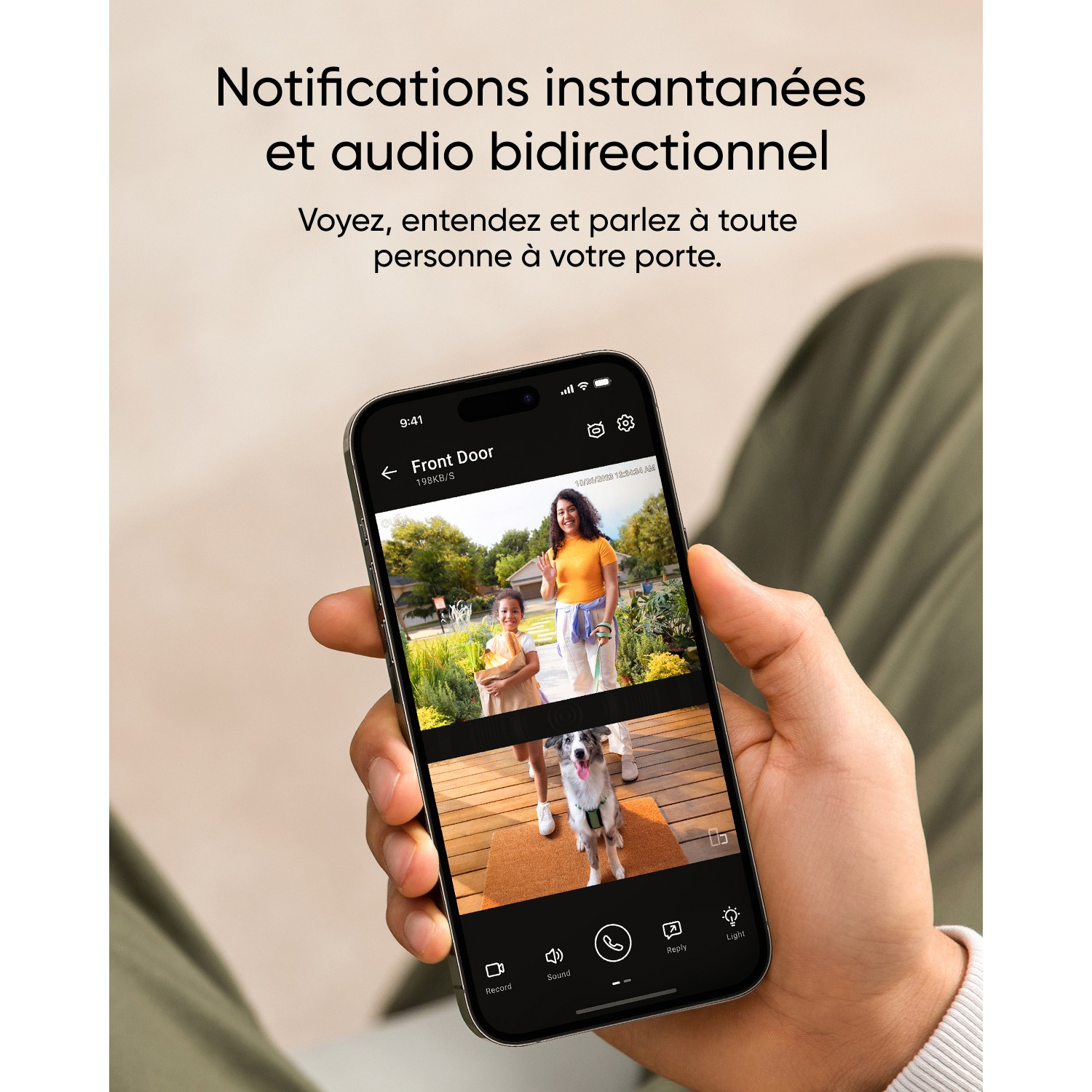 Une main tenant un téléphone affichant un flux vidéo d'une caméra de porte d'entrée.