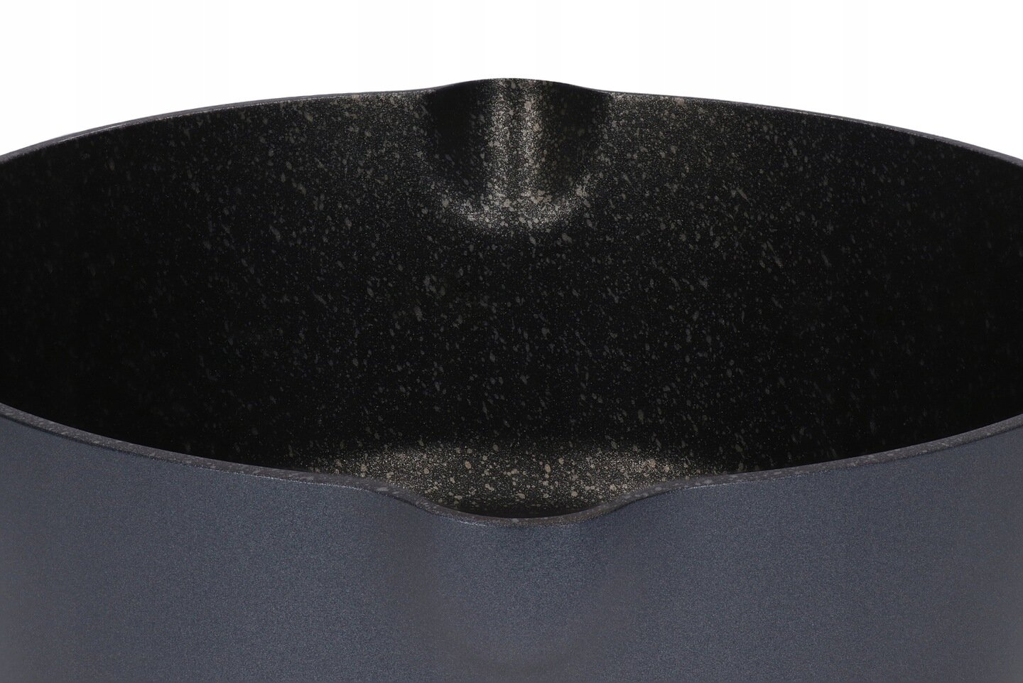 Zbliżenie na ciemne, teksturowane, szaro-czarne wnętrze garnka o lekko zakrzywionym kształcie, na białym tle.