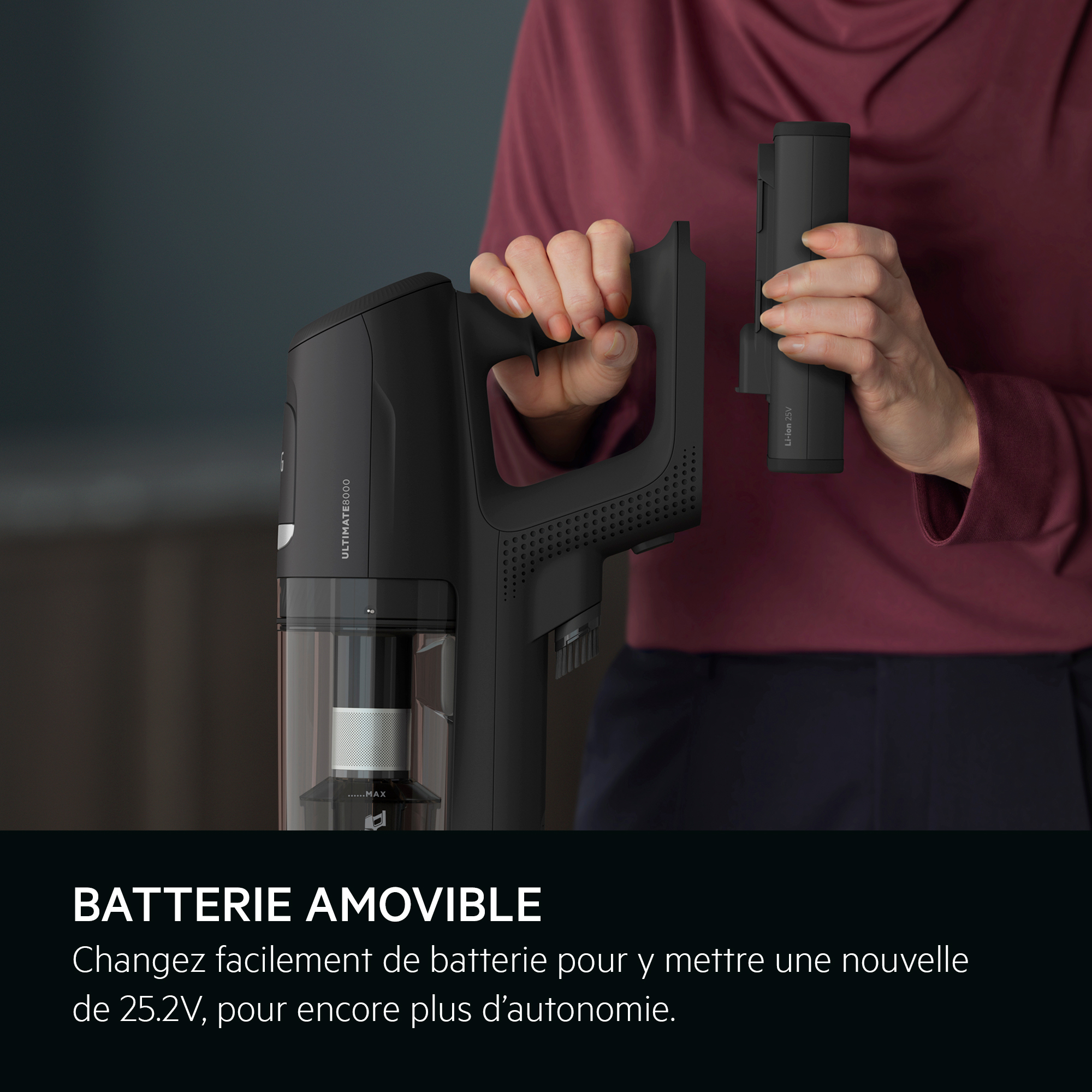 Une personne tient un aspirateur noir et une batterie. Un texte en français est sur l'image.