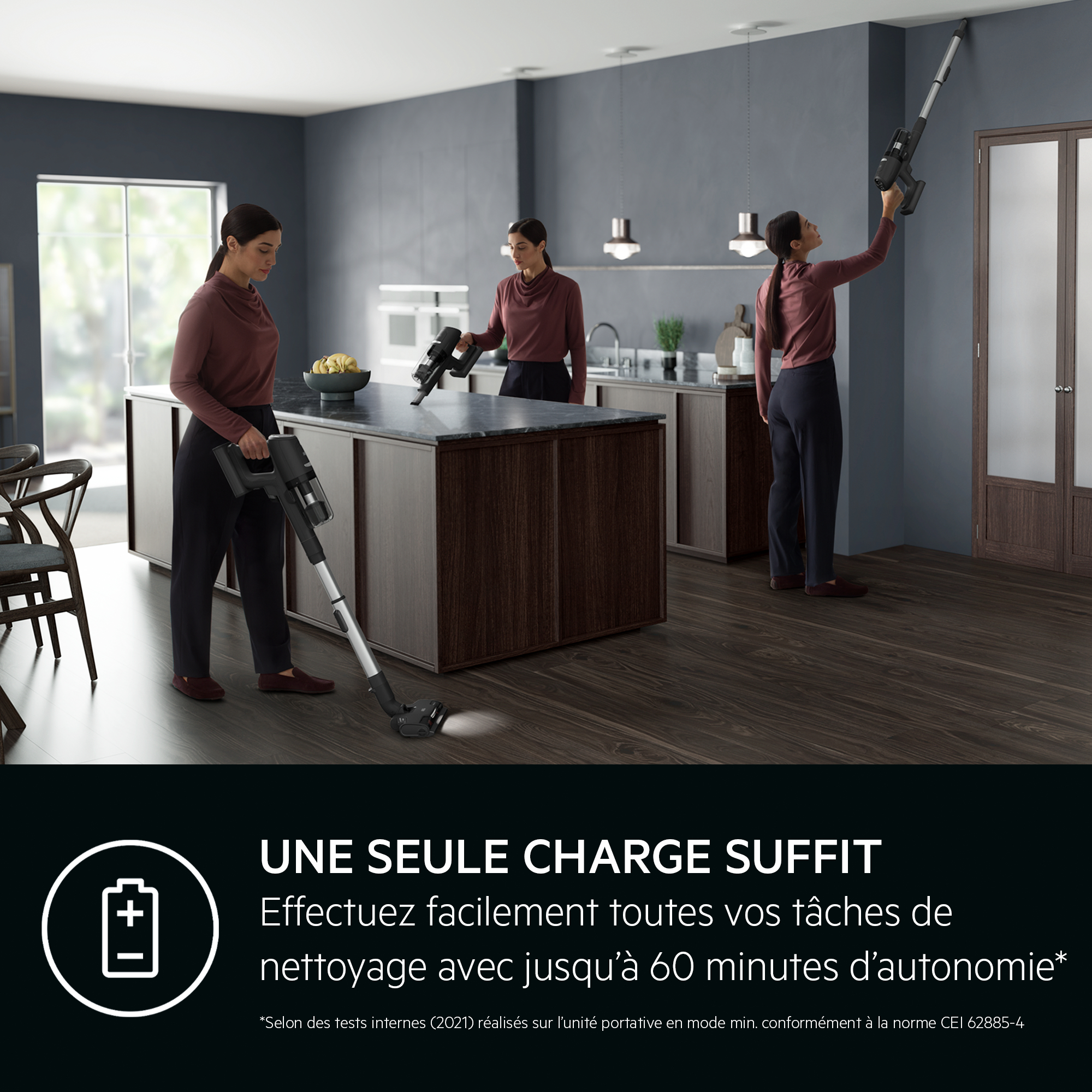 Femme utilisant un aspirateur sans fil. Décor sombre gris et noir en arrière-plan.