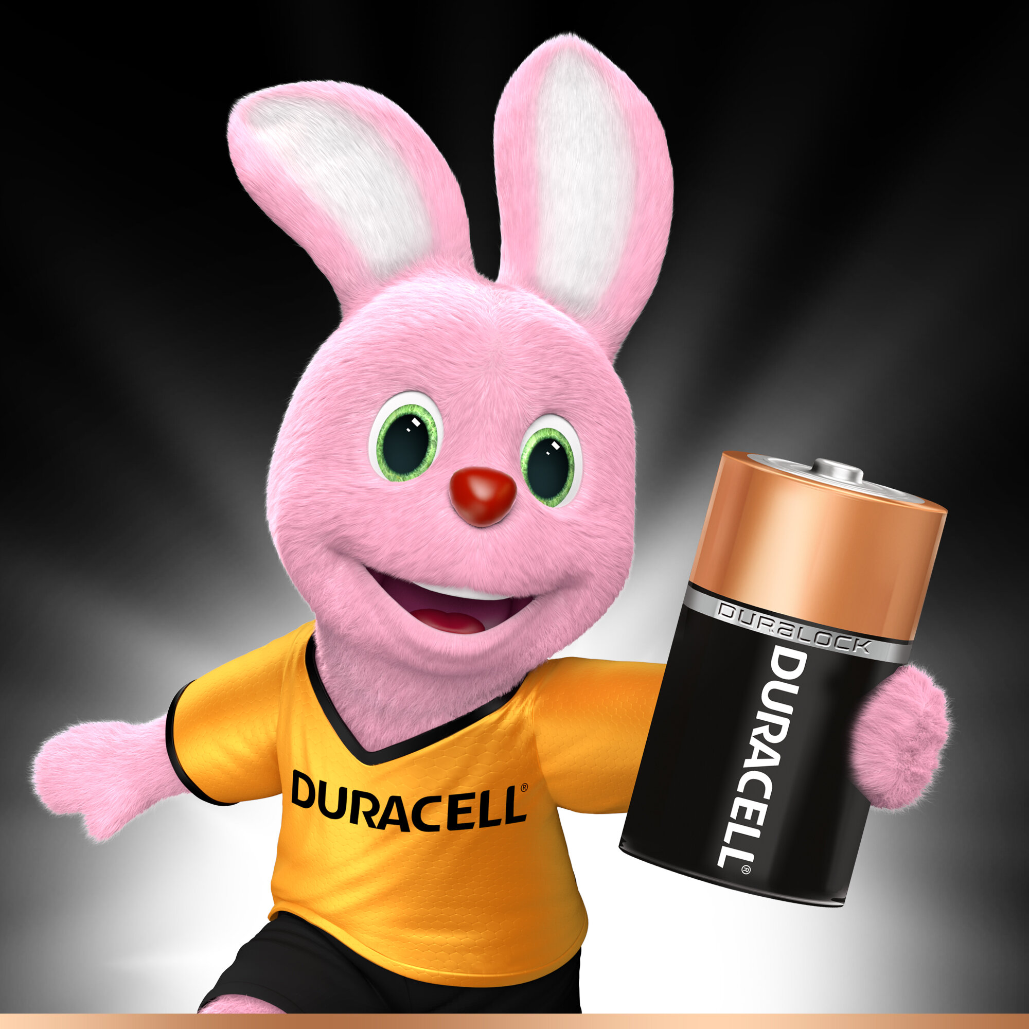 Królik Duracell trzymający baterię Duracell. Królik jest różowy i ma na sobie żółtą koszulkę.