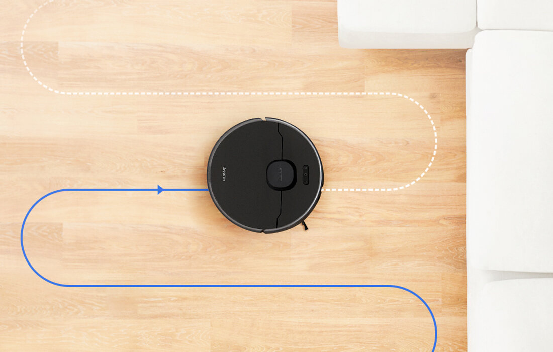 Odkurzacz robot, czarny, na drewnianej podłodze. Trasa oznaczona niebieskimi i białymi liniami.