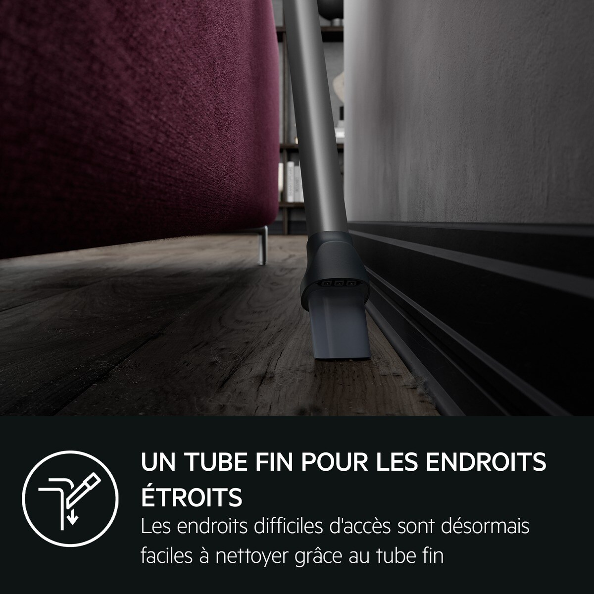 Buse d'aspirateur nettoyant près des meubles, illustrant l'accès aux espaces étroits.
