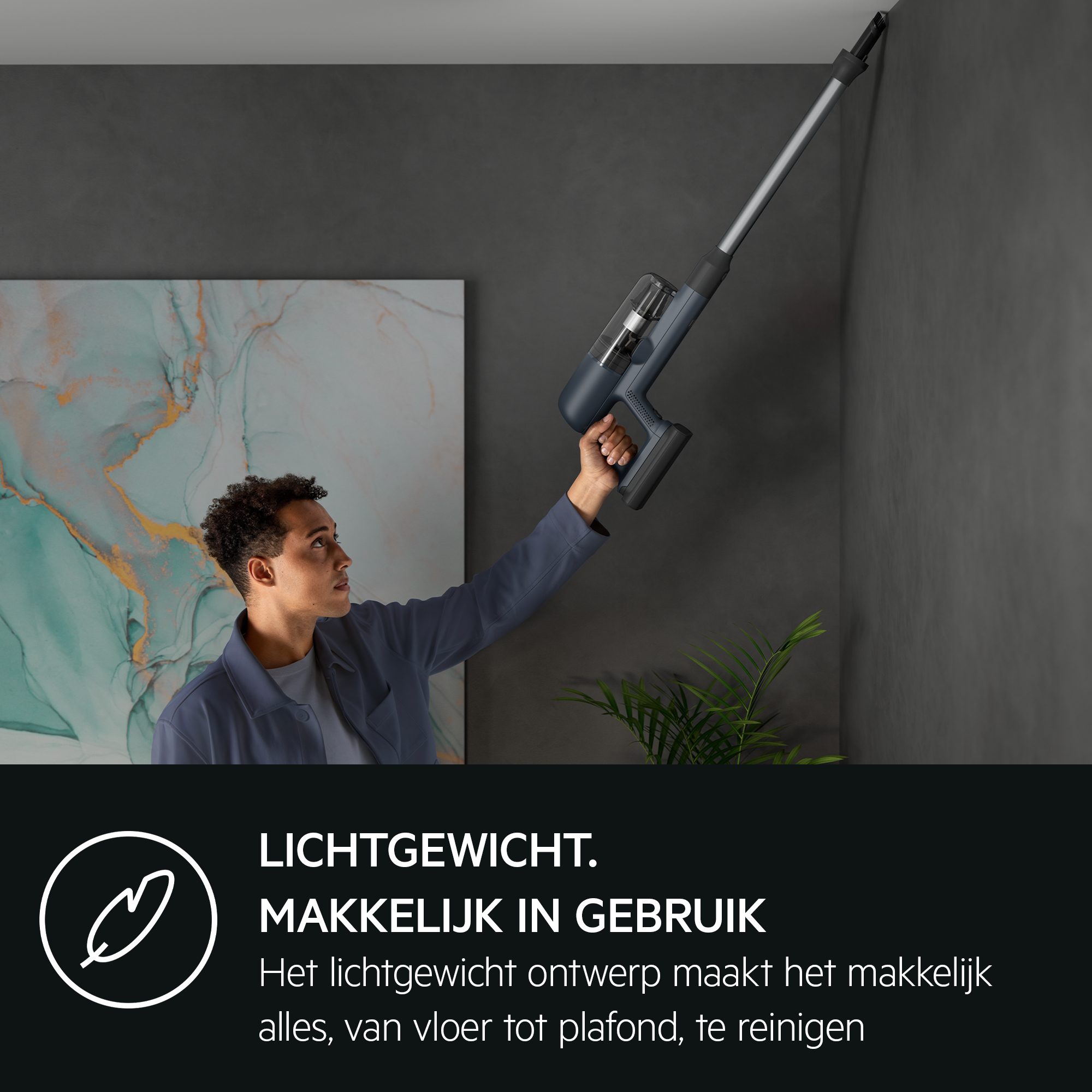 A man using a cordless vacuum cleaner on a wall, with text below.