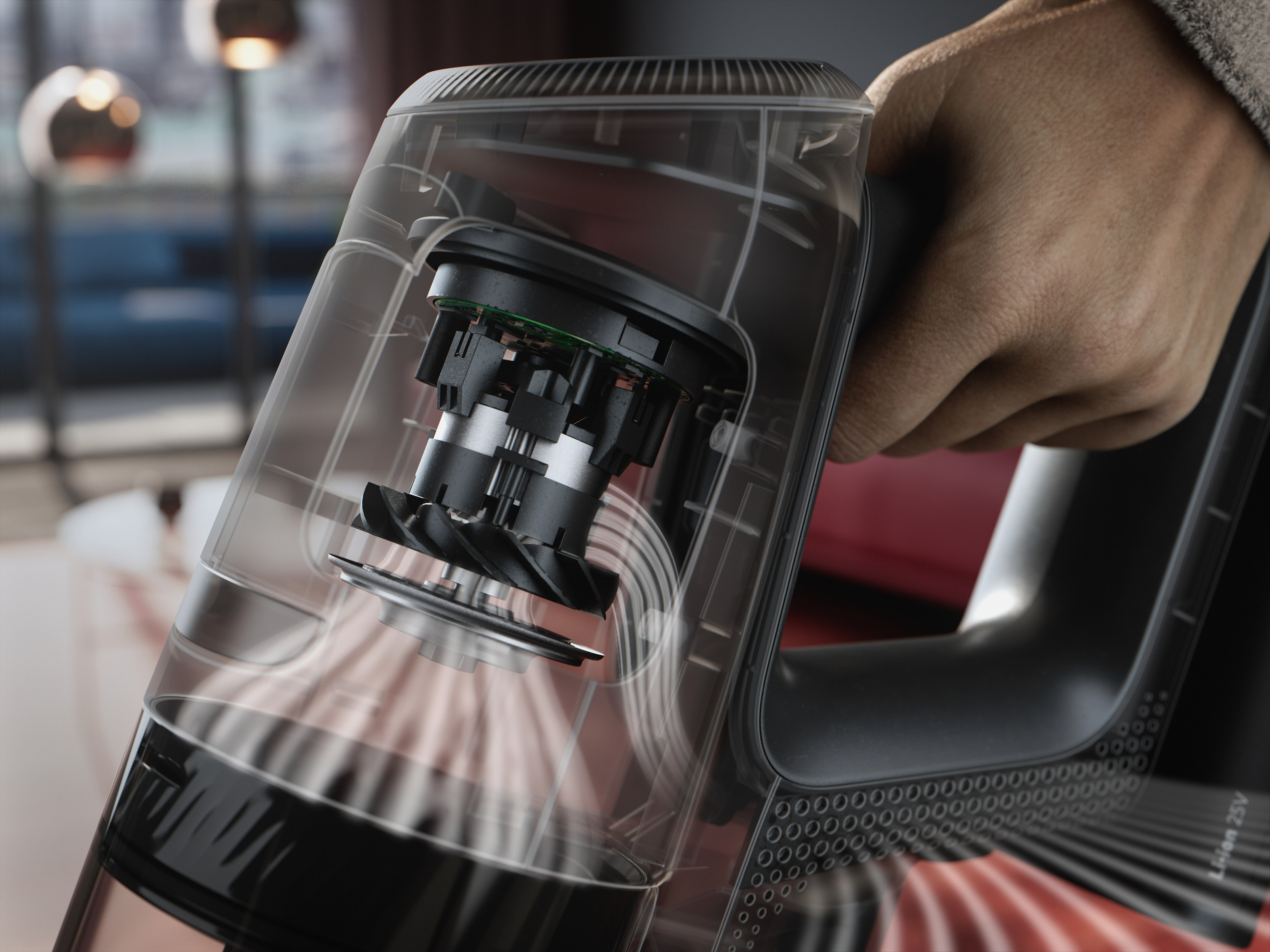 Une main tenant un aspirateur transparent montrant le fonctionnement interne.