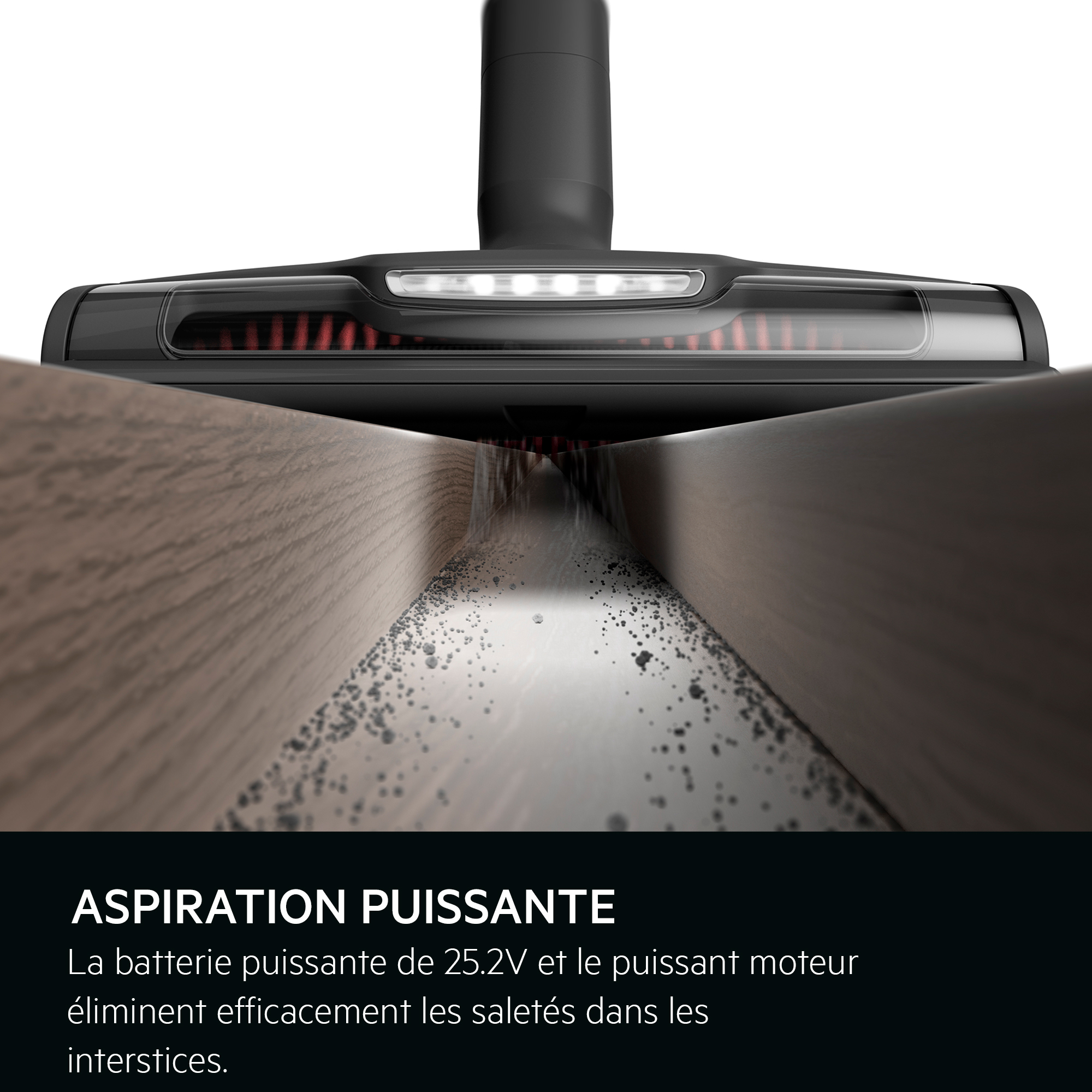 Une tête d'aspirateur nettoie un plancher en bois, enlevant la saleté.