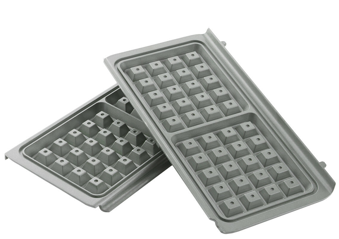 Dwie szare płyty do gofrownicy. Płyty mają wzór kratki. Na białej powierzchni.