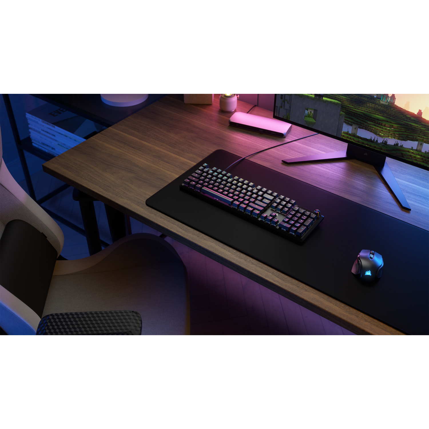 Gaming-opstelling: Toetsenbord, muis en monitor op een houten bureau, met sfeerverlichting.