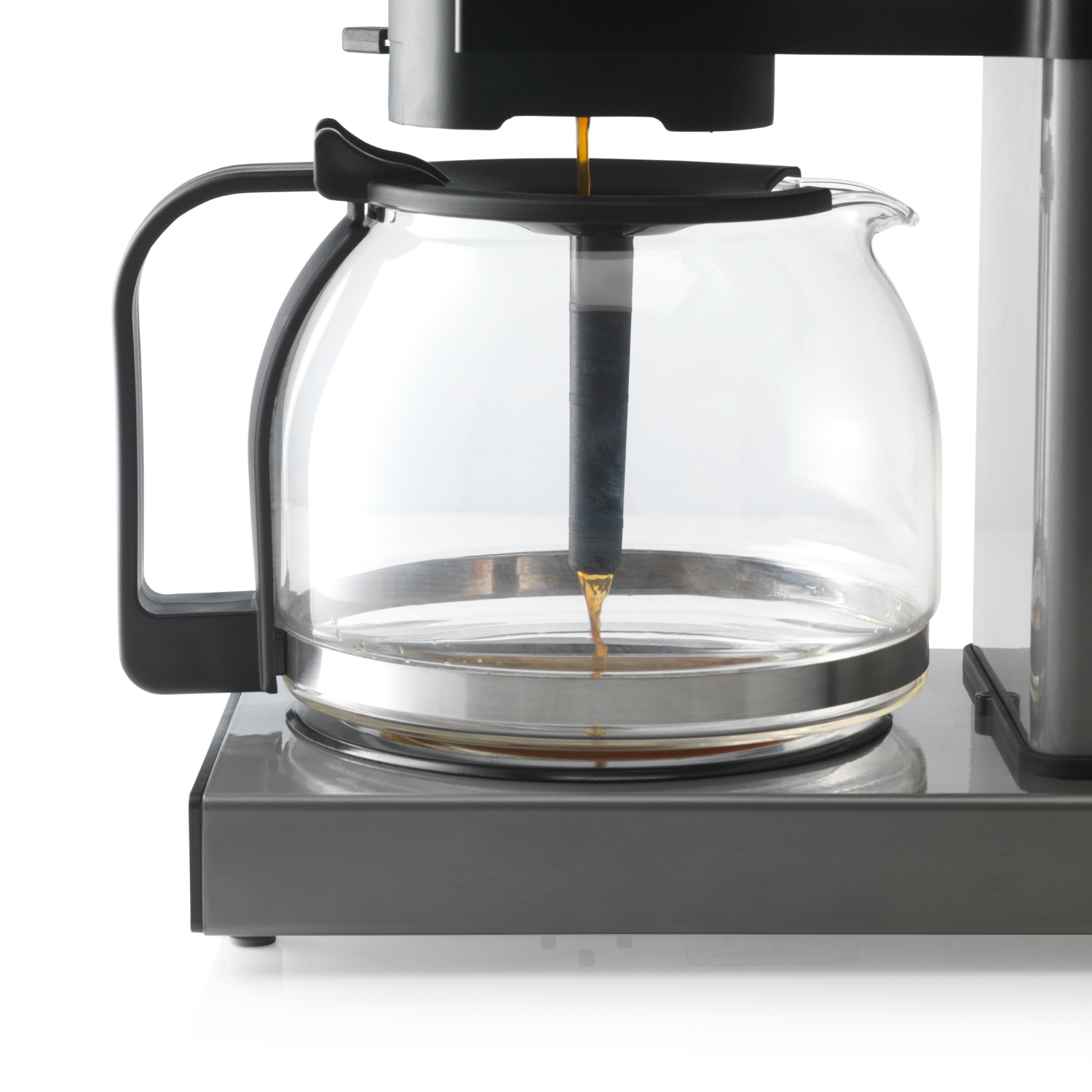 Koffiezetapparaat met glazen kan, koffie druppelend erin.