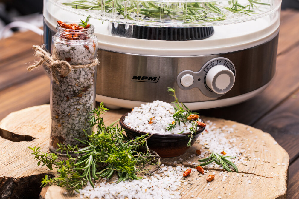 Słoik soli z ziołami. Suszarka i przyprawy na drewnie.