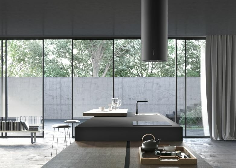 Nowoczesna czarna kuchnia z wyspą, oknem i widokiem na zieleń.