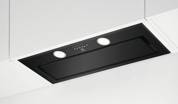 Czarny okap kuchenny wbudowany w sufit. Posiada dwa światła i przyciski sterowania.
