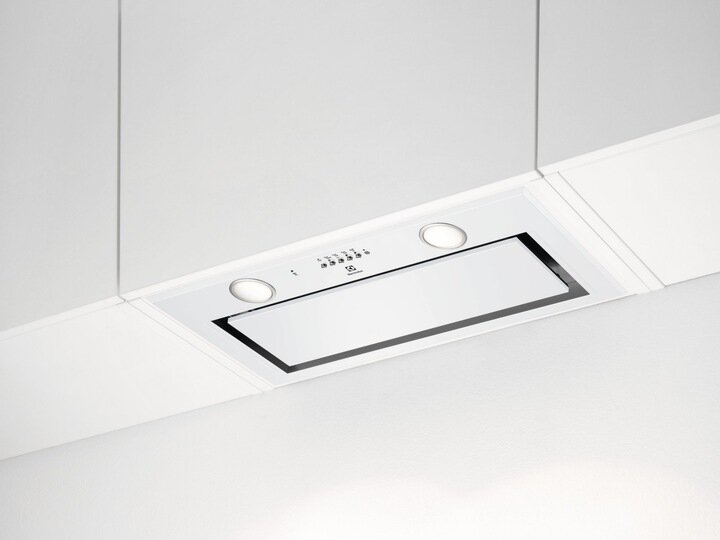 Biały okap kuchenny zamontowany pod białymi szafkami, z dwoma światłami.